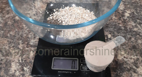 oats and seeds added into the bowl with protein powder scoop in front