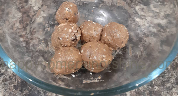 Chocolate chip protein balls rolled into balls in the mixing bowl