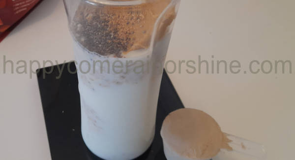 all chocolate protein smoothie ingredients added with scoop of protein powder to the side
